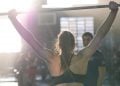 Atleta di crossfit, vista di spalle, si allena con il bilanciere